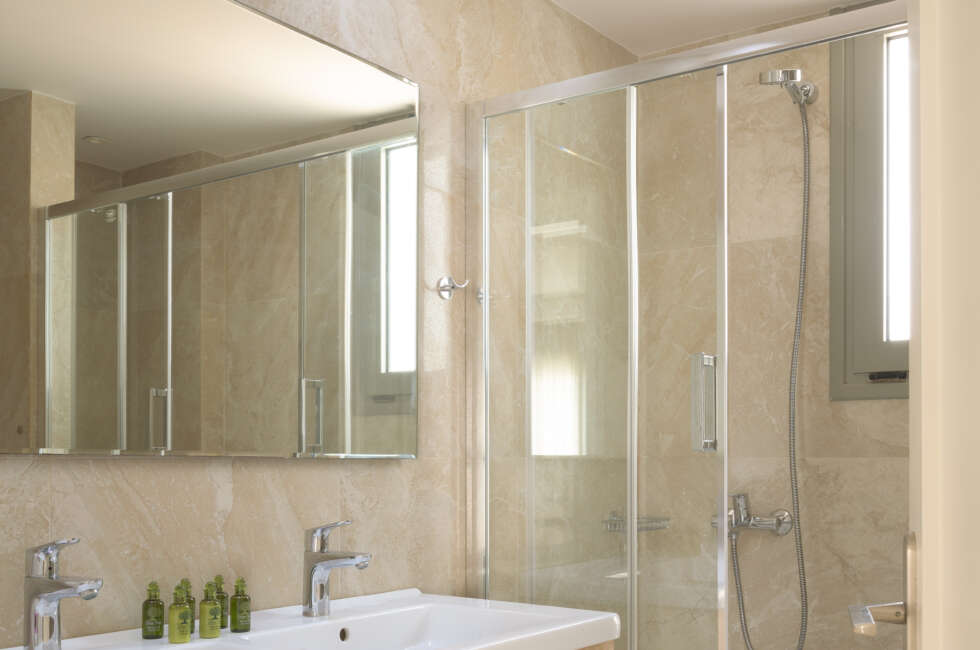 The bathroom features a double sink and walk in shower.